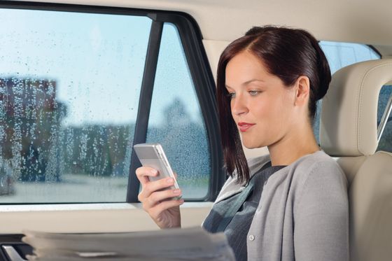 Woman in towncar on cell phone.