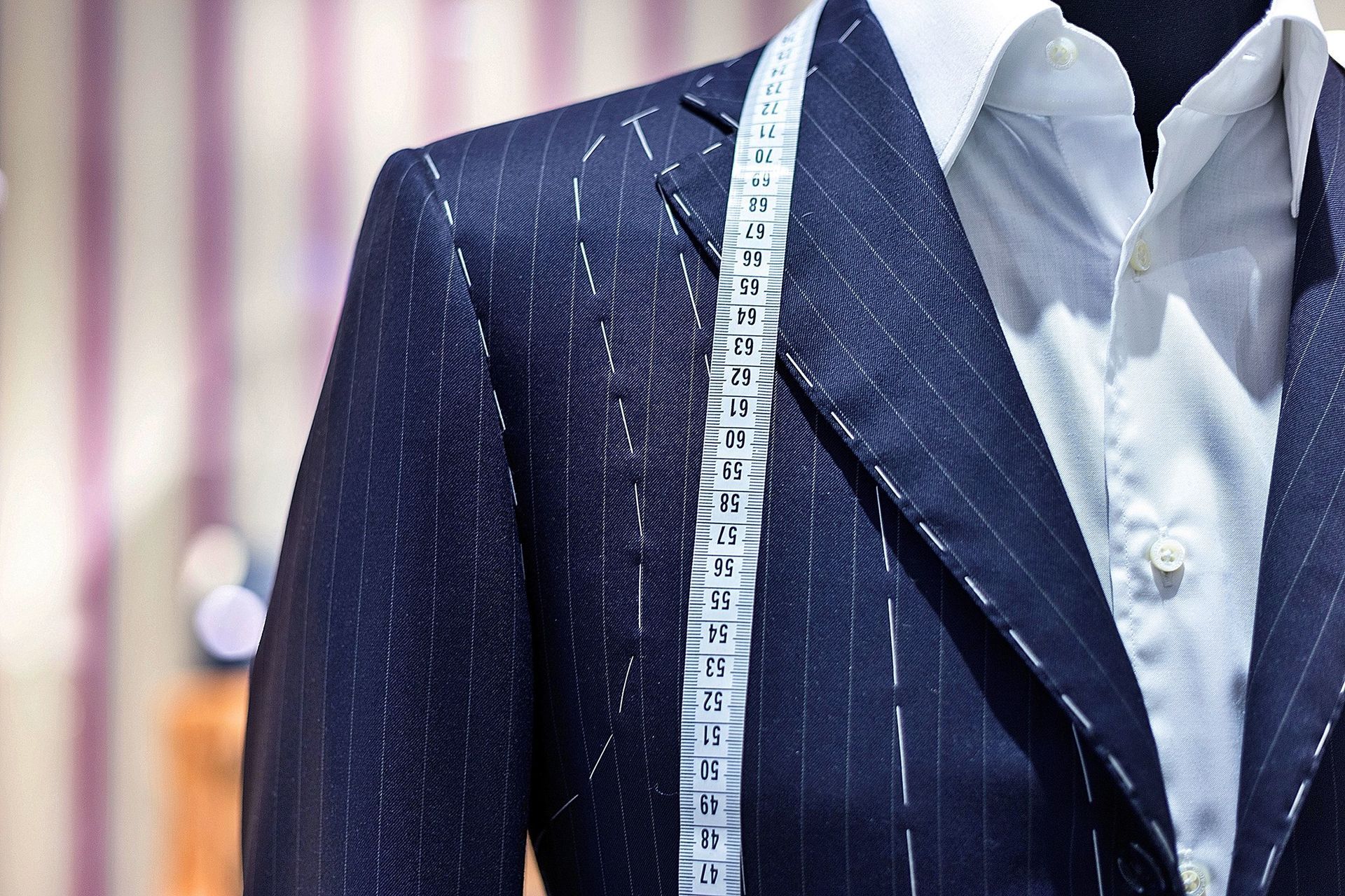 Men's Suit Un-Constructed ready to be customised, with a measuring tape hanging over it.
