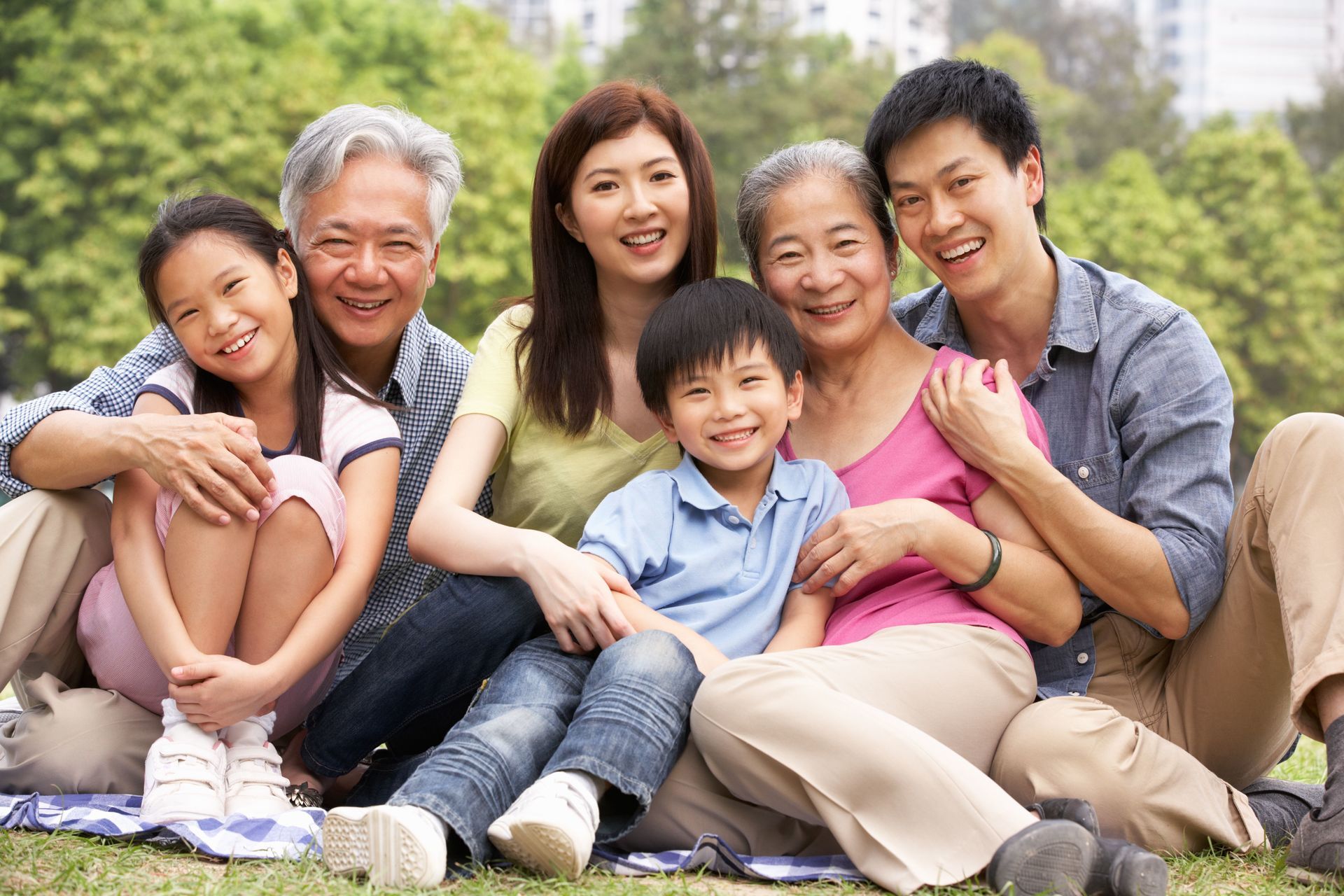 Three generations of an Asian family , posing for a photo in the park.