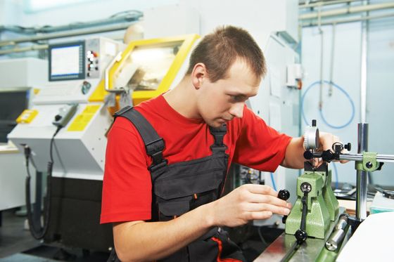 Qualitätskontrolleur im präzisen Messprozess zur Sicherstellung der Fertigungstoleranzen