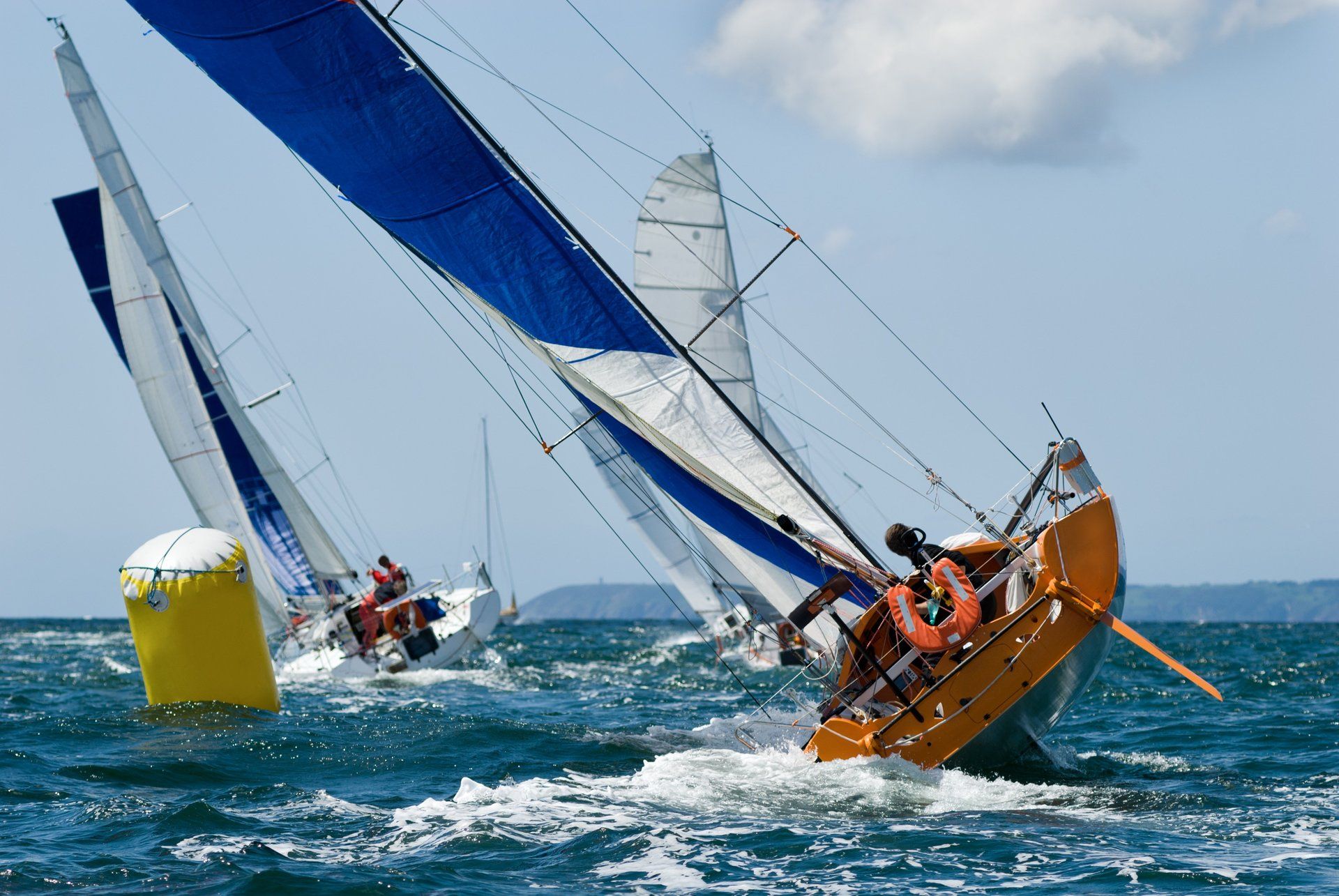 Three large sailing yachts, racing in strong winds.