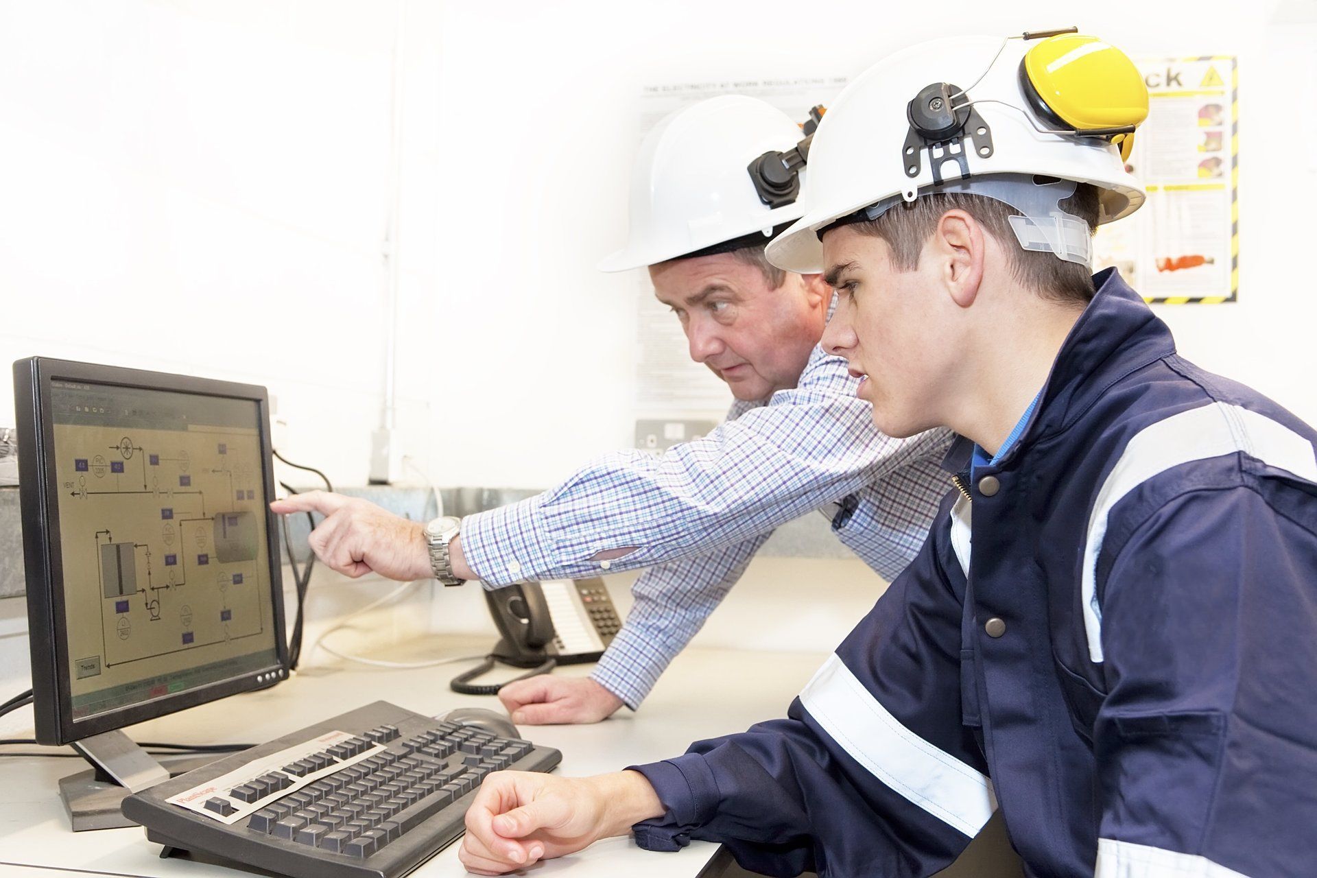 Commit to Lifelong Learning.  A supervisor teaching young apprentice about refinery systems.