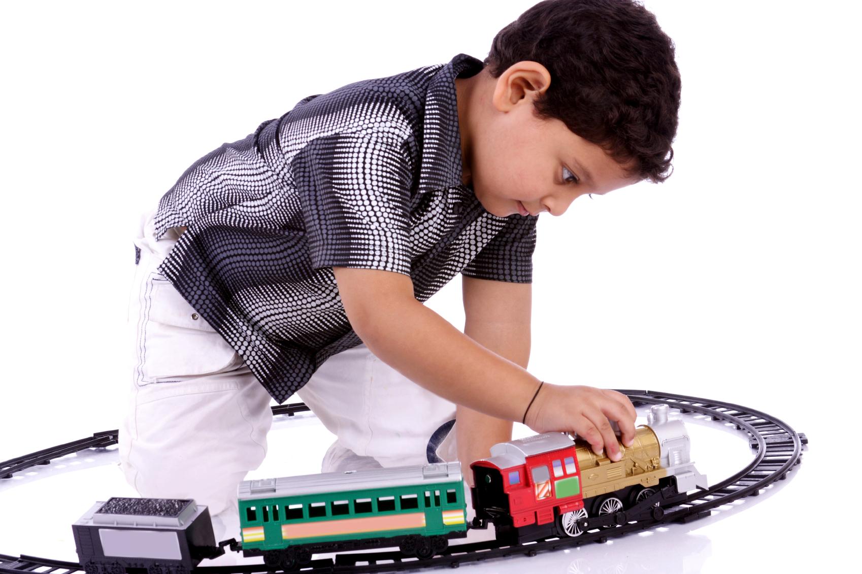 Little boy playing with his toy trains