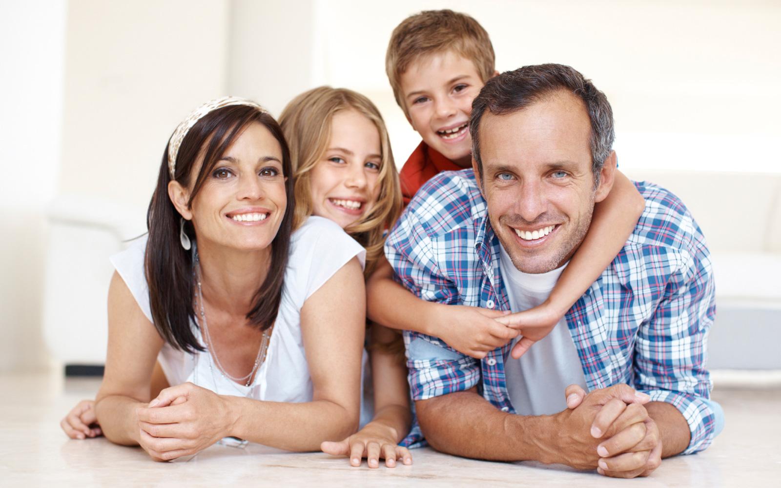 Familie mit Vater, Mutter, Sohn, Tochter im Wohnzimmer