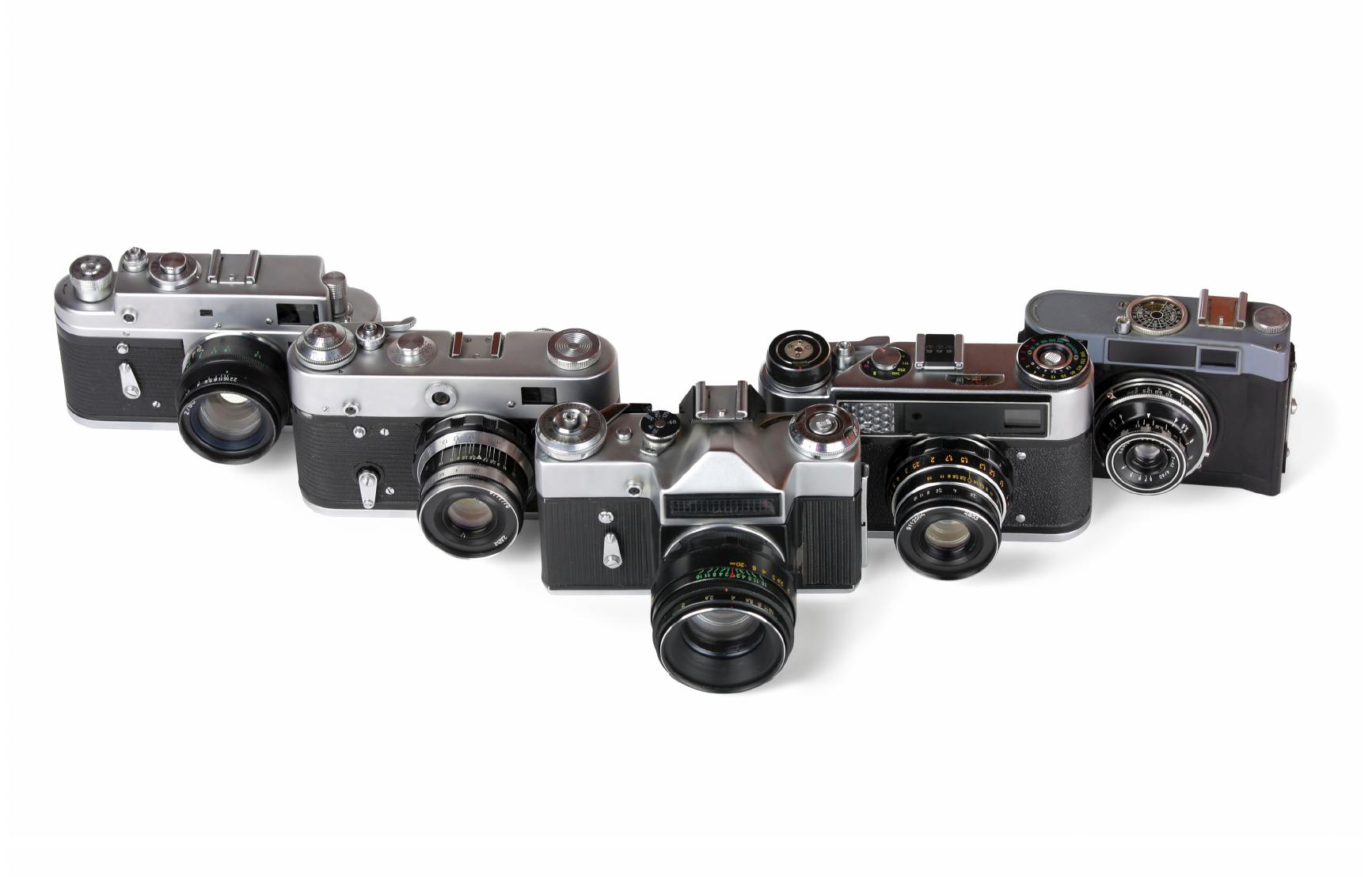 Five small cameras sitting on a table