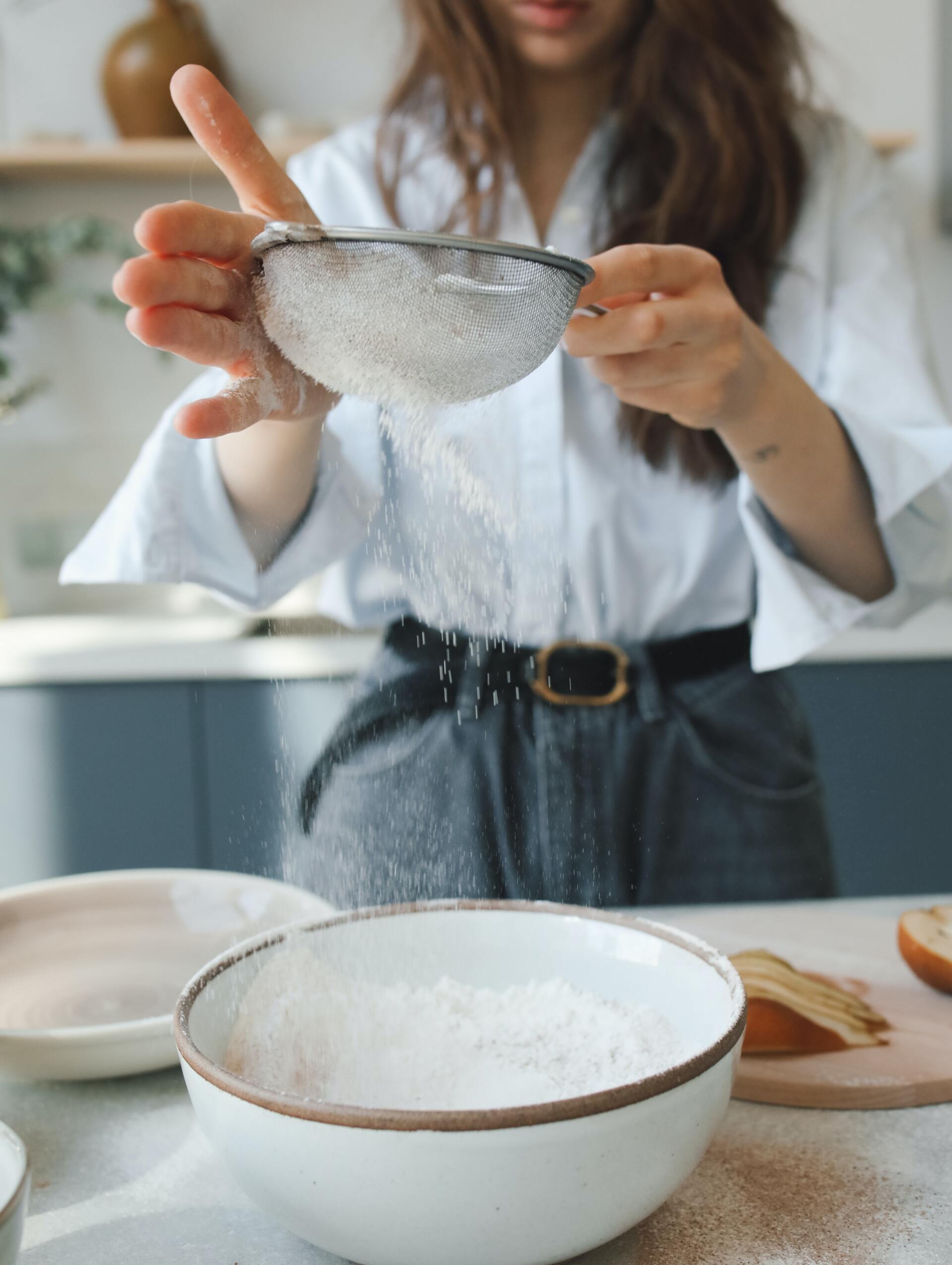woman in kitchen sifting flour