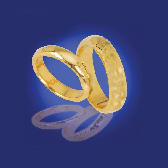 Zwei zusammengehörige Eheringe in Gelbgold mit Struktur.