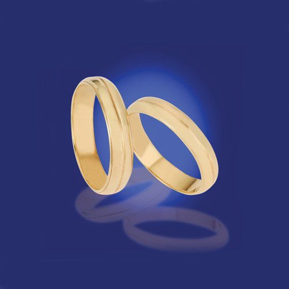 Zwei zusammengehörige schmale Eheringe in Gelbgold mit einer durchgehenden Linie als Gravur.