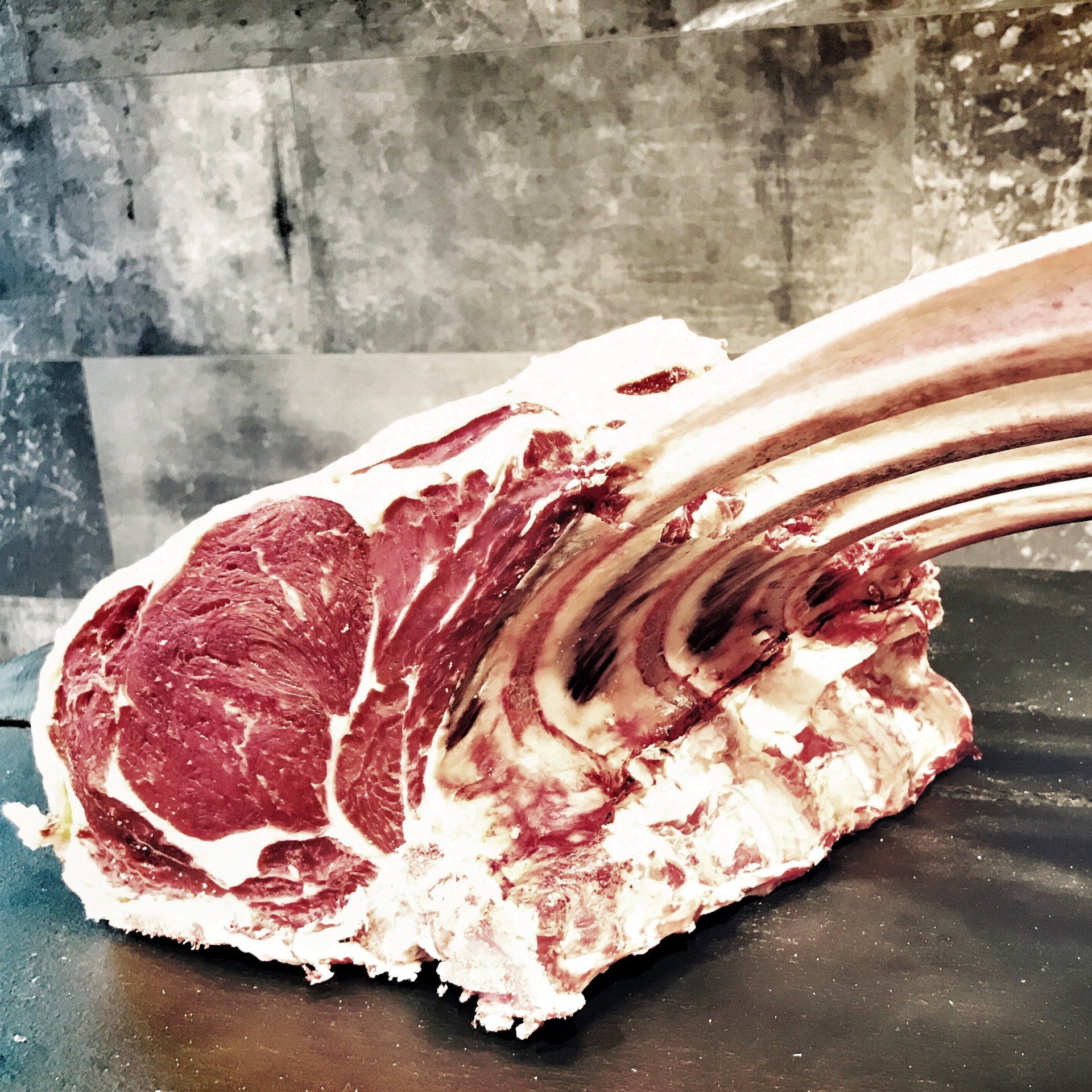 Präsentation eines Dry Aged Tomahawk Steaks.