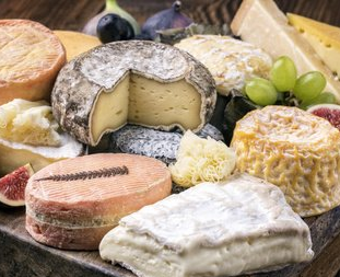 Auswahl verschiedener Käsesorten auf einer Servierplatte.