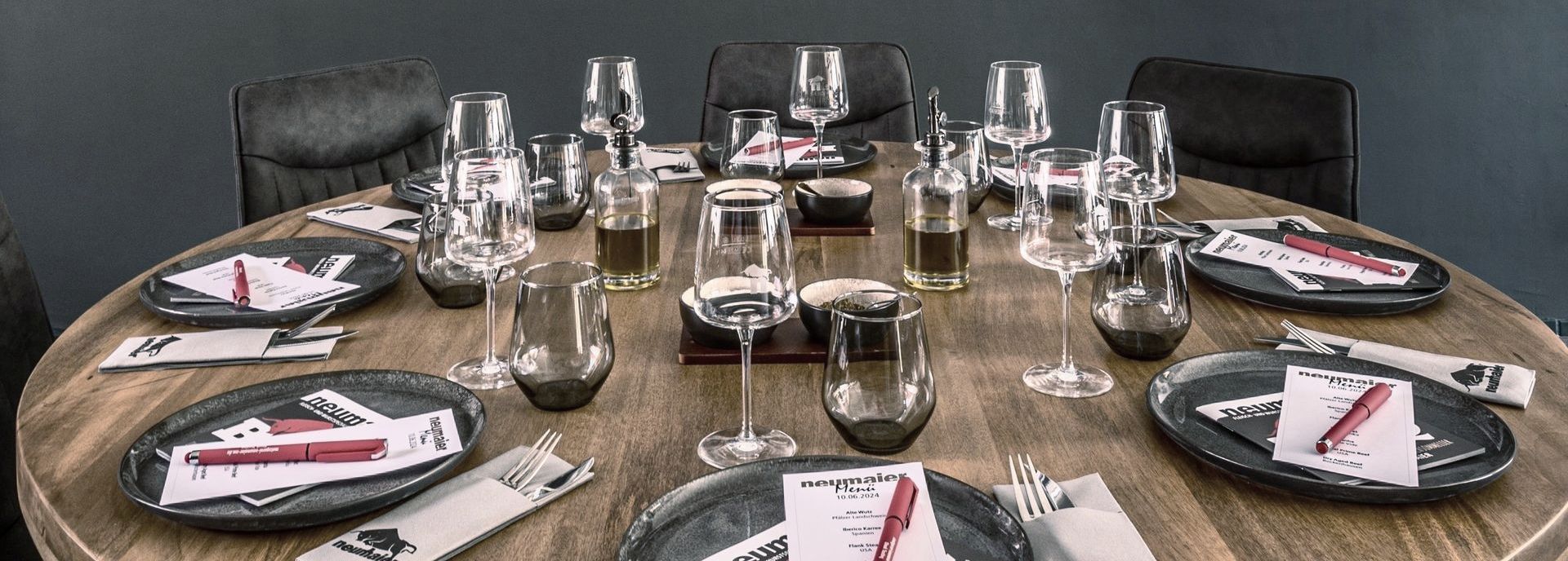 Gedeckter Tisch für Steaktastingverkostung mit Besteck, Gläsern und Tellern sowie Gewürzen.