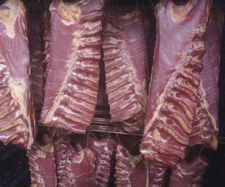 Mehrere Baconstücke in Nahaufnehme im Hängeraum präsentiert.