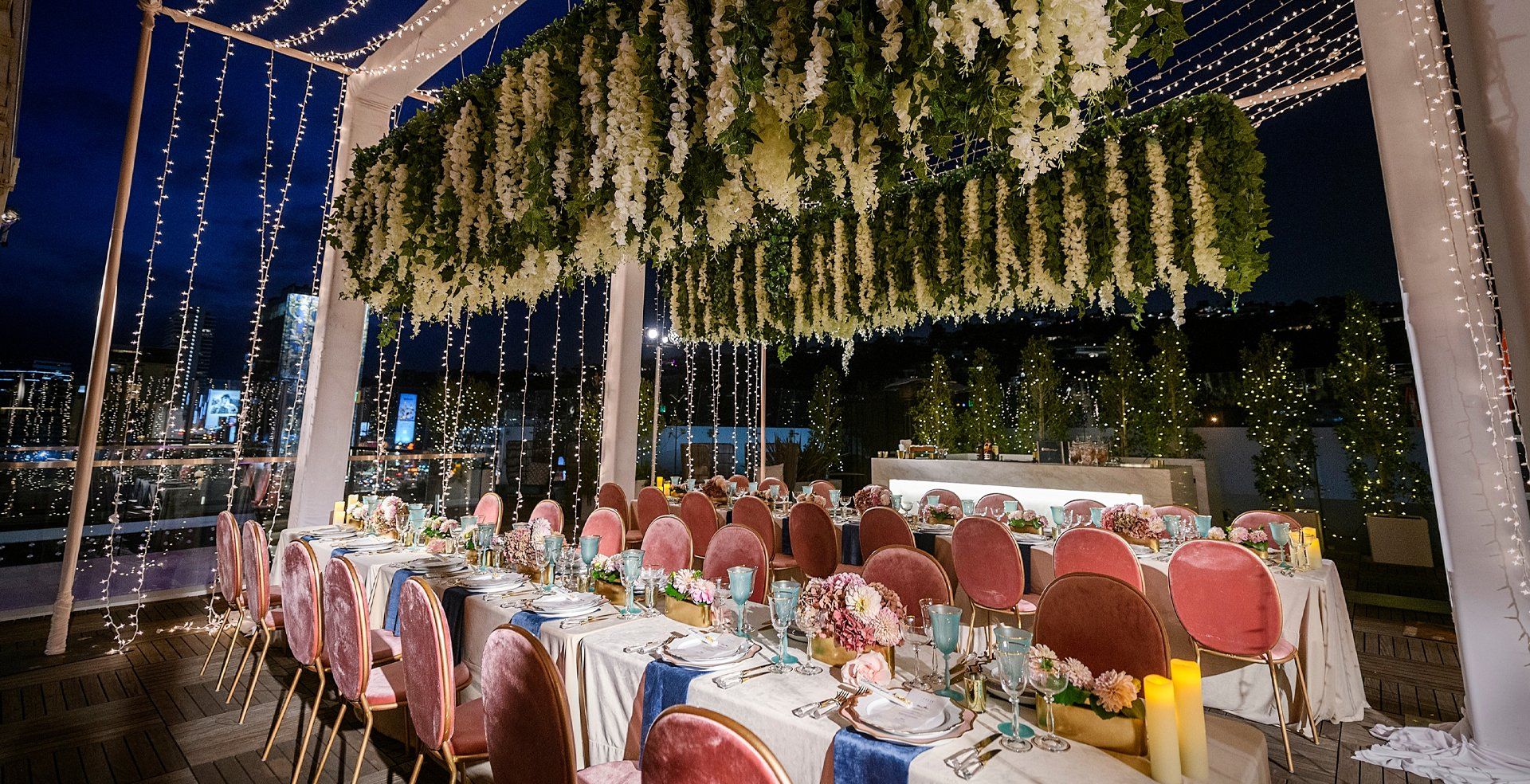 An image of a speciality table under a makeshift canopy with florals hanging from the top.
