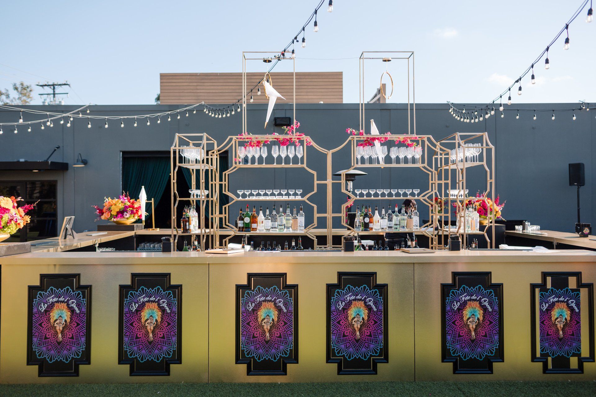 An image of a large bar setup featuring lavish bar backs that hold speciality glasses and drinks.