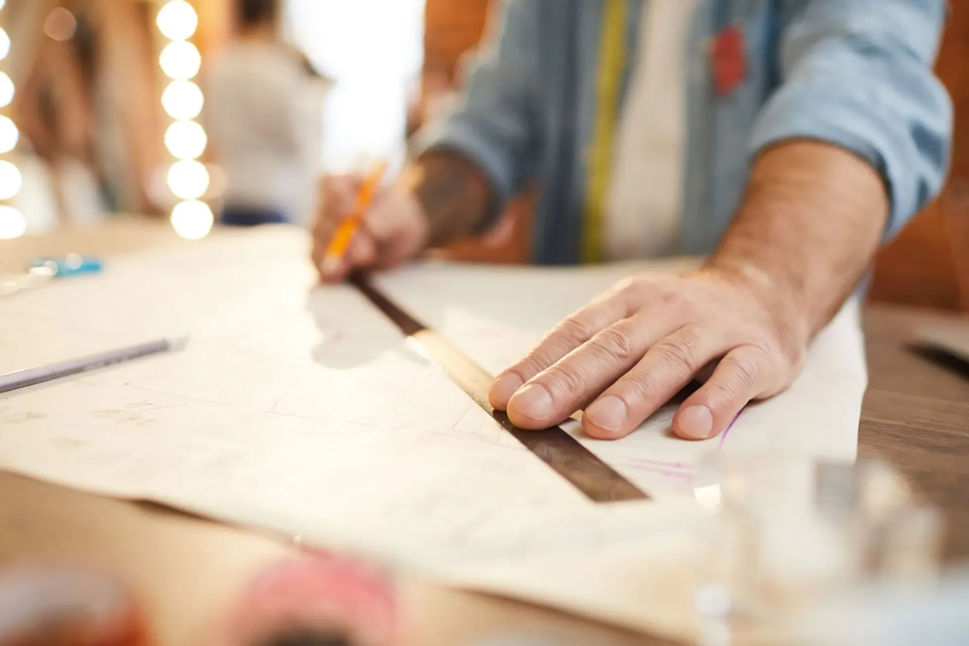 Camisas a medida, sastre trazando los cortes y medidas de la camisa en tela blanca