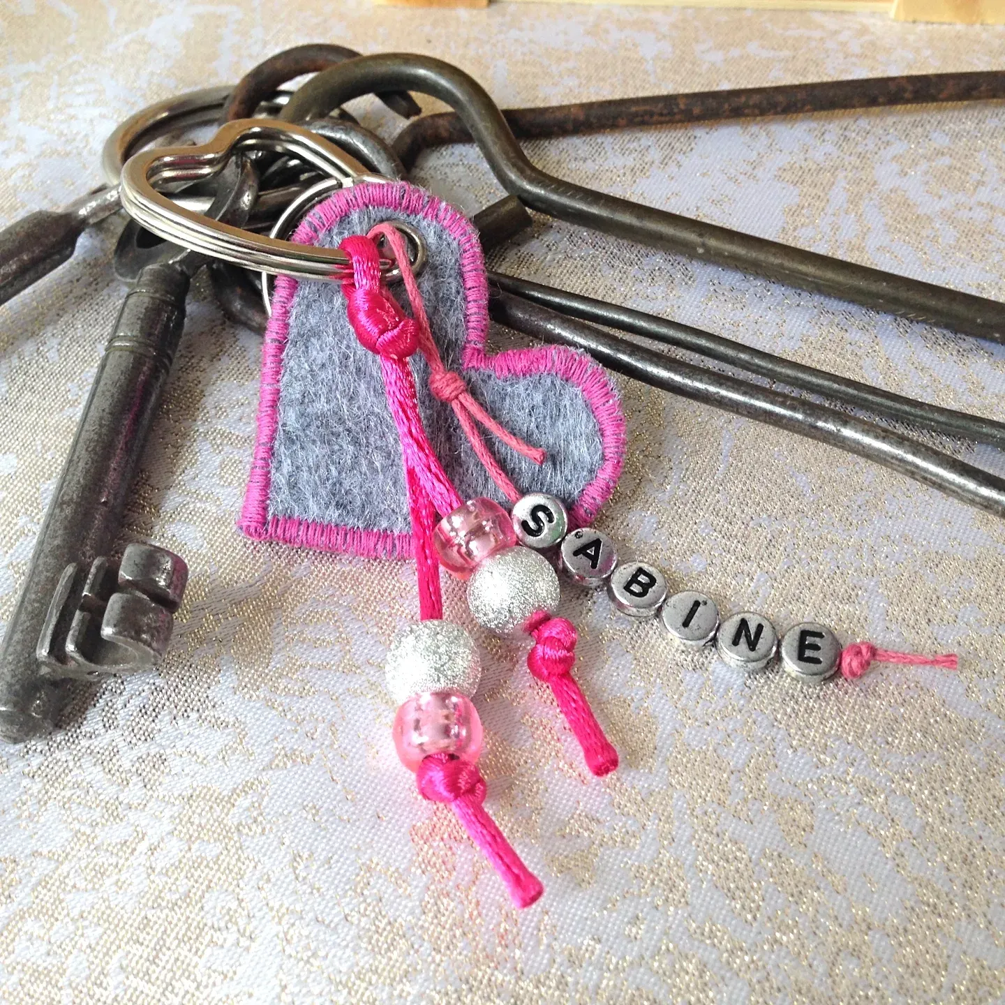 schluesselband filz grau pink