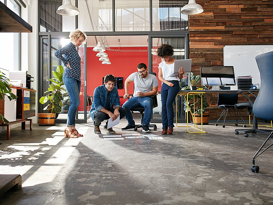 Team betrachtet ein Bild auf dem Boden