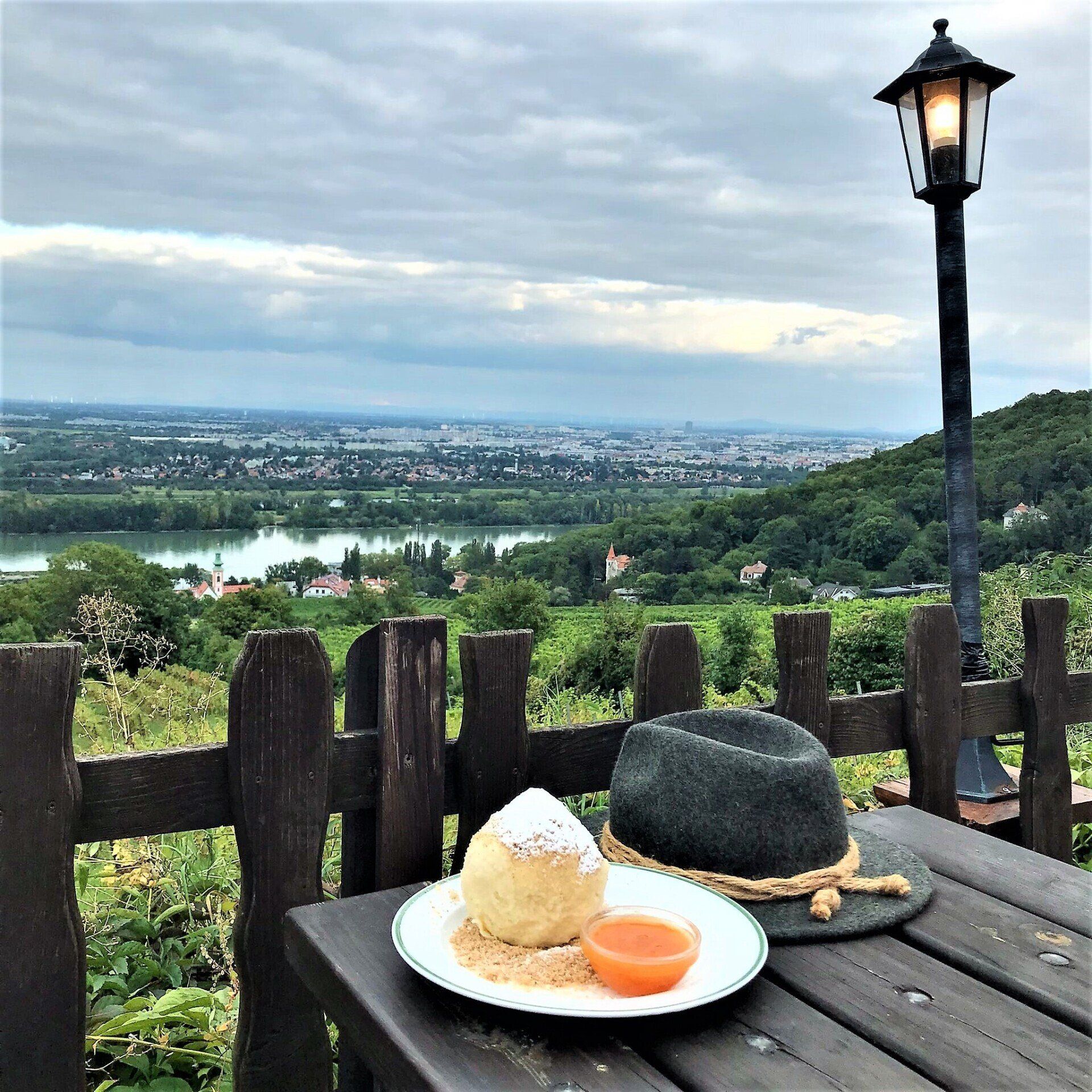 Blick auf Wien und die Donau vom Heurigen Hirt mit Marillenknödel und Wanderhut.