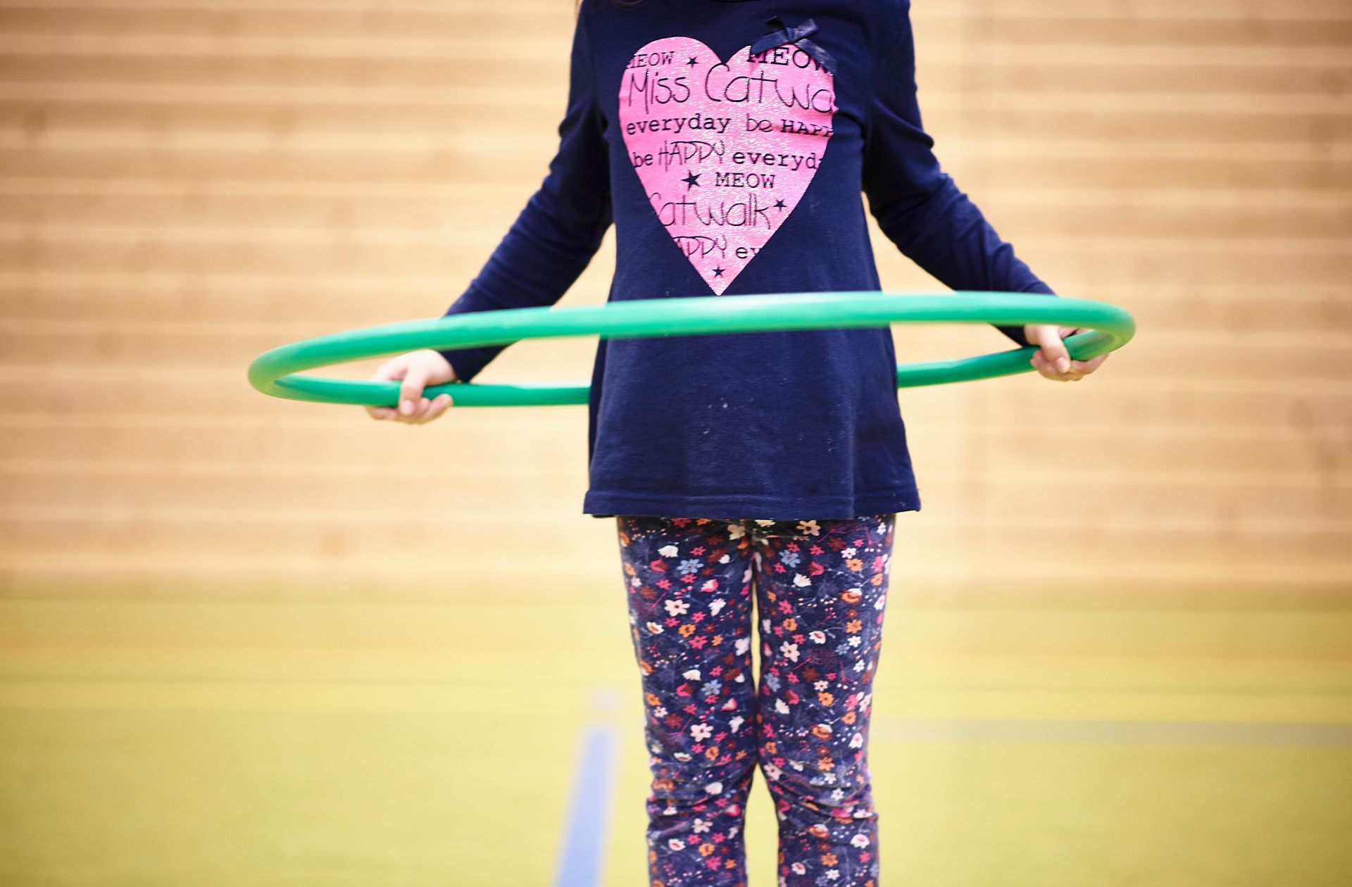 Eine Trainierende übt mit dem Hulla-Hoop-Reifen in der Turnhalle.