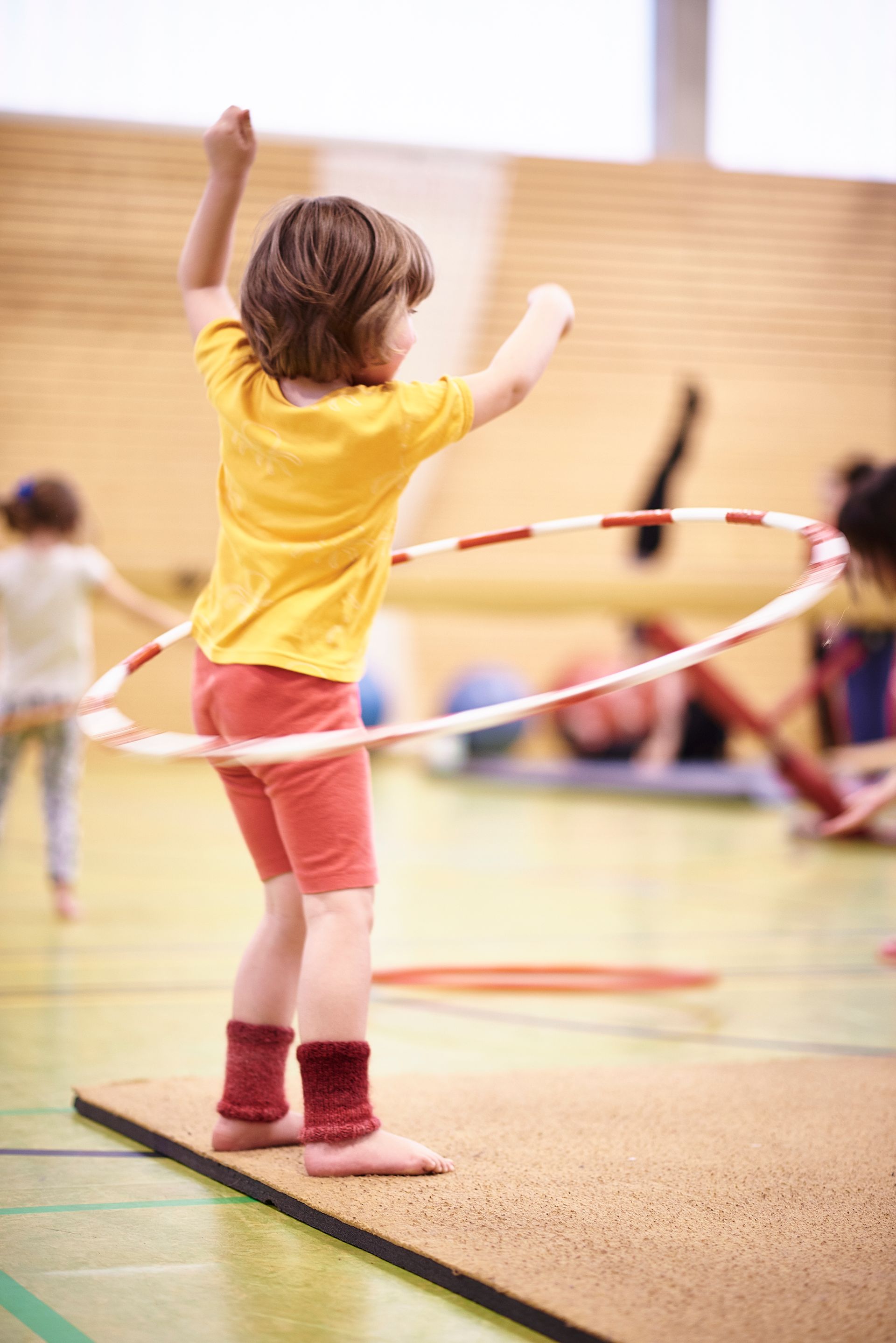 Ein Trainierender übt mit dem Hulla-Hoop-Reifen.