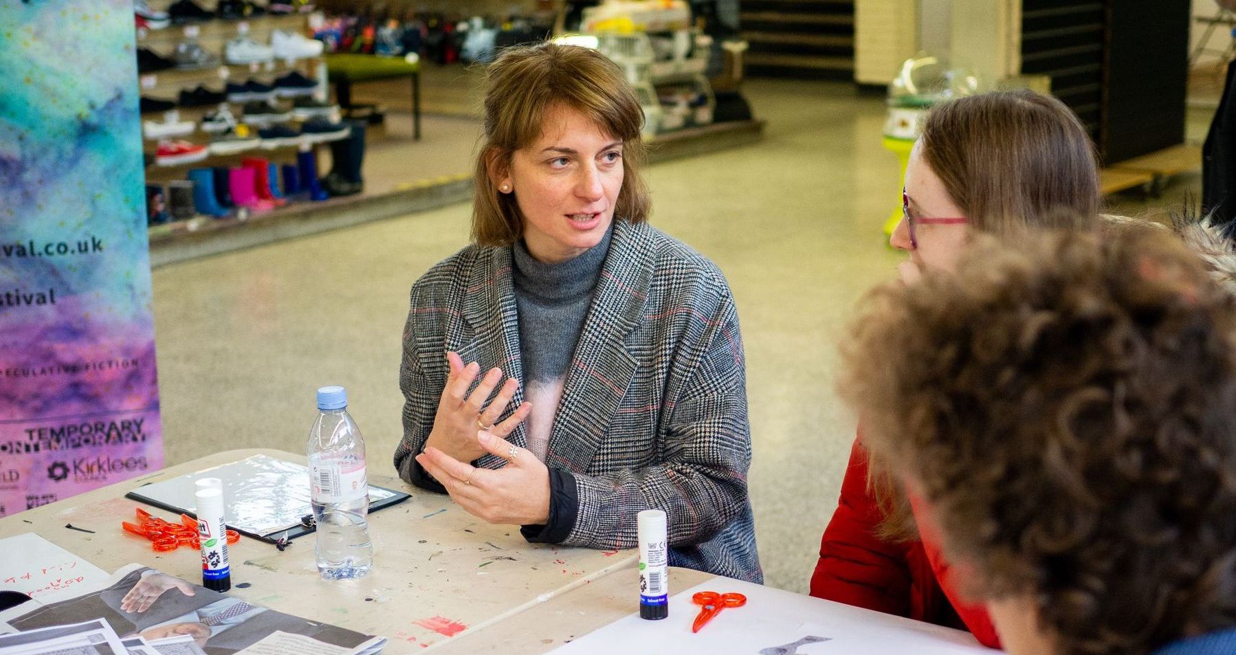 Photograph showing three people at a table with craft materials