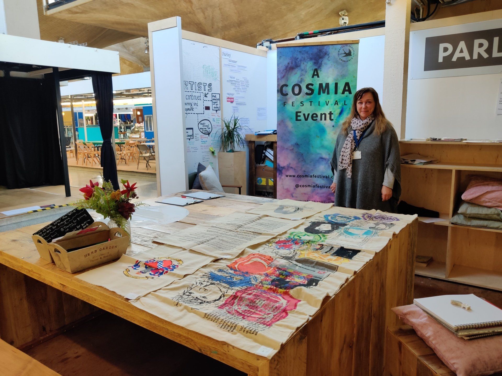 Photograph of artist with textile samples in Parlour at Queensgate market