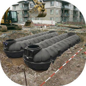 Einbau einer unterirdischen Regenwasserzisterne auf einer Baustelle für Wohnungsbau.