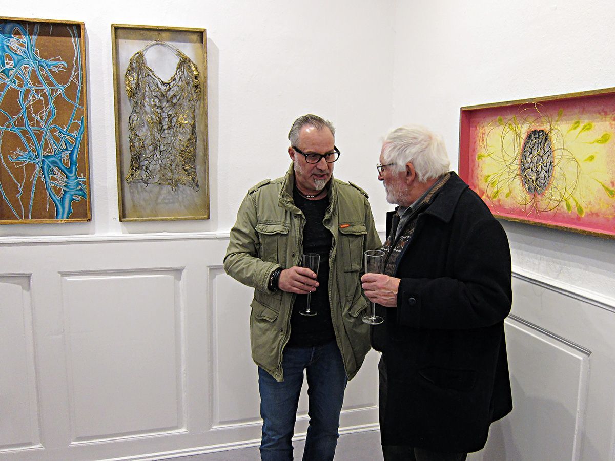Zwei Ausstellungsbesucher im Gespräch vor Werken der Künstler Klaus Burth, Doris Rabung und Dieter Weißenberger. Foto: Dieter Weißenberger