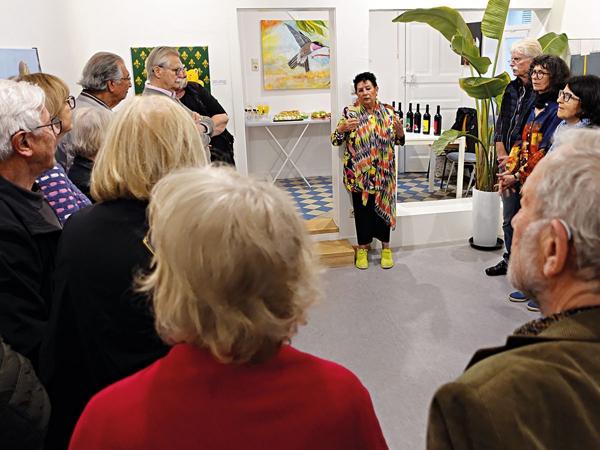 Die Künstlerin Sibylle Krastel-Dibbern spricht auf ihrer Vernissage zu einem Kreis von Ausstellungsbesuchern. Foto: Dieter Weißenberger