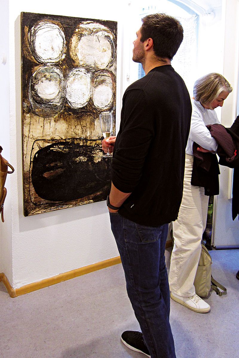 Ein junger Mann betrachtet konzentriert ein Werk der Künstlerin Dorothea Panhuyzen. Foto: Dieter Weißenberger