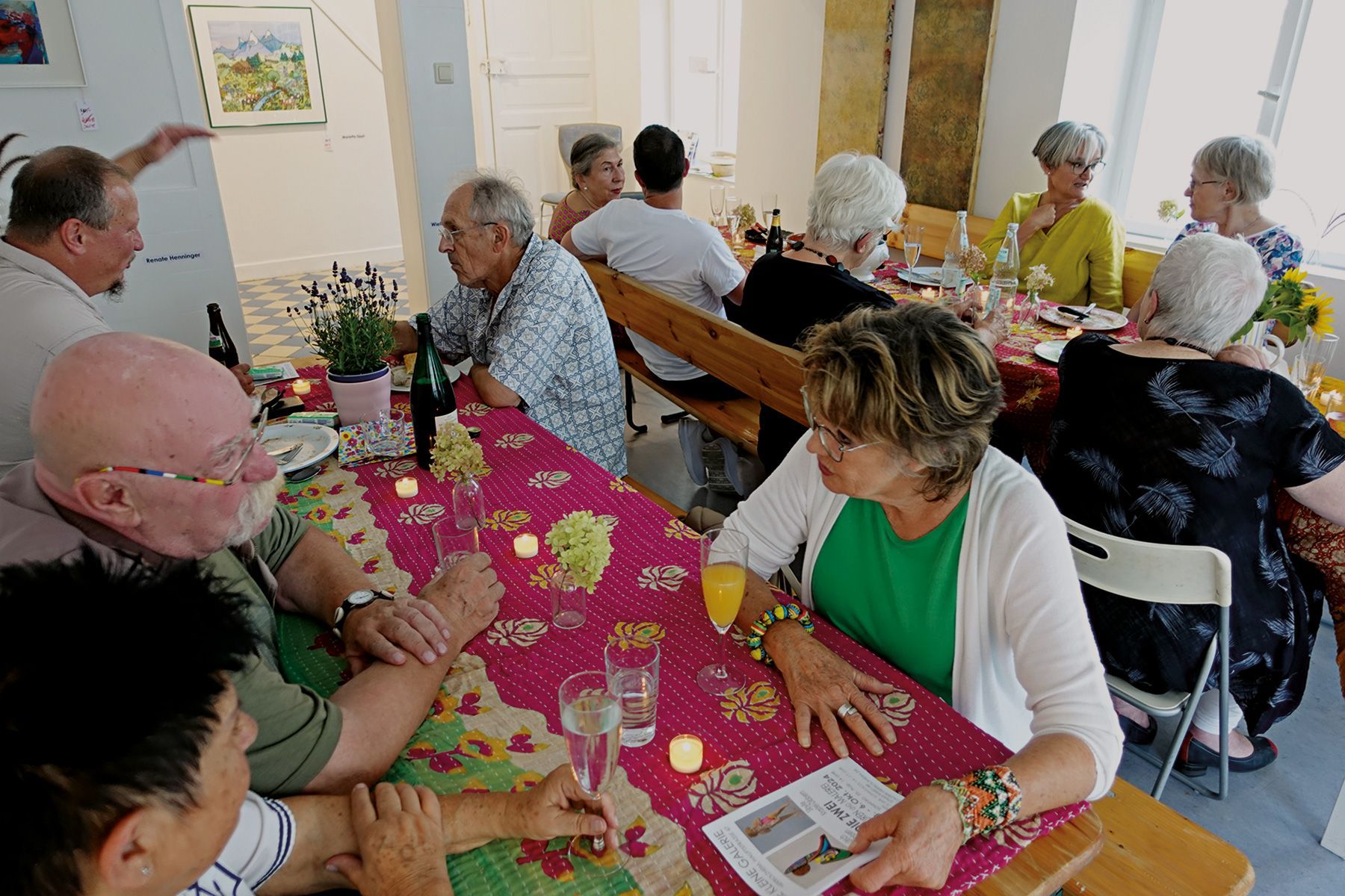 Mitglieder des Vereins beim Sommerfest an Tischen in der Galerie. Foto: Dieter Weißenberger