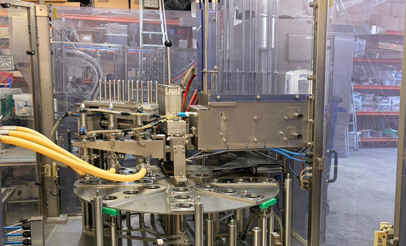 Fully automatic infeed cup filling and closing machine