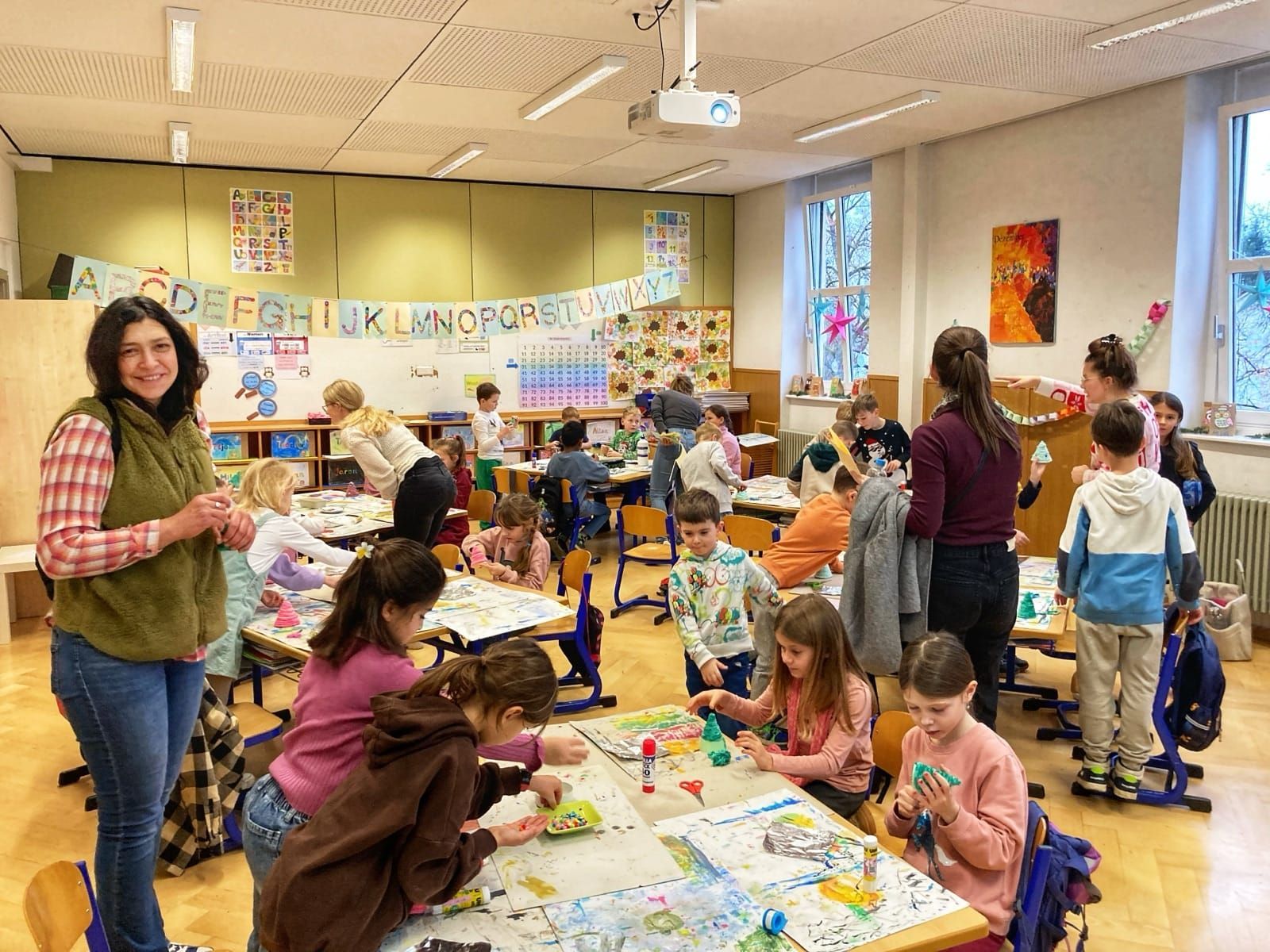 Kinder und Erwachsene basteln an Gruppentischen.