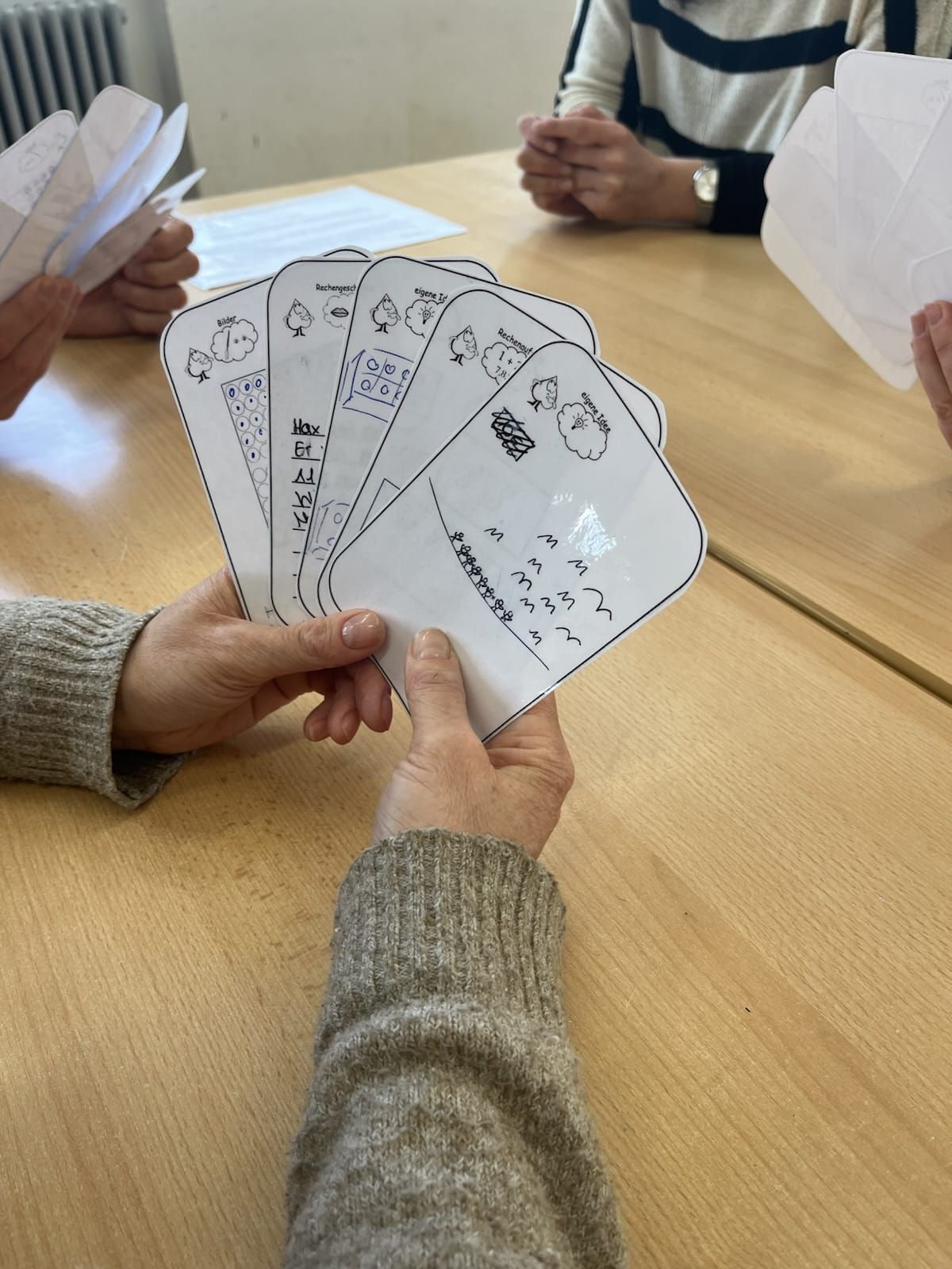 Lehrerin hält ein Mathe-Kartenspiel in den Händen