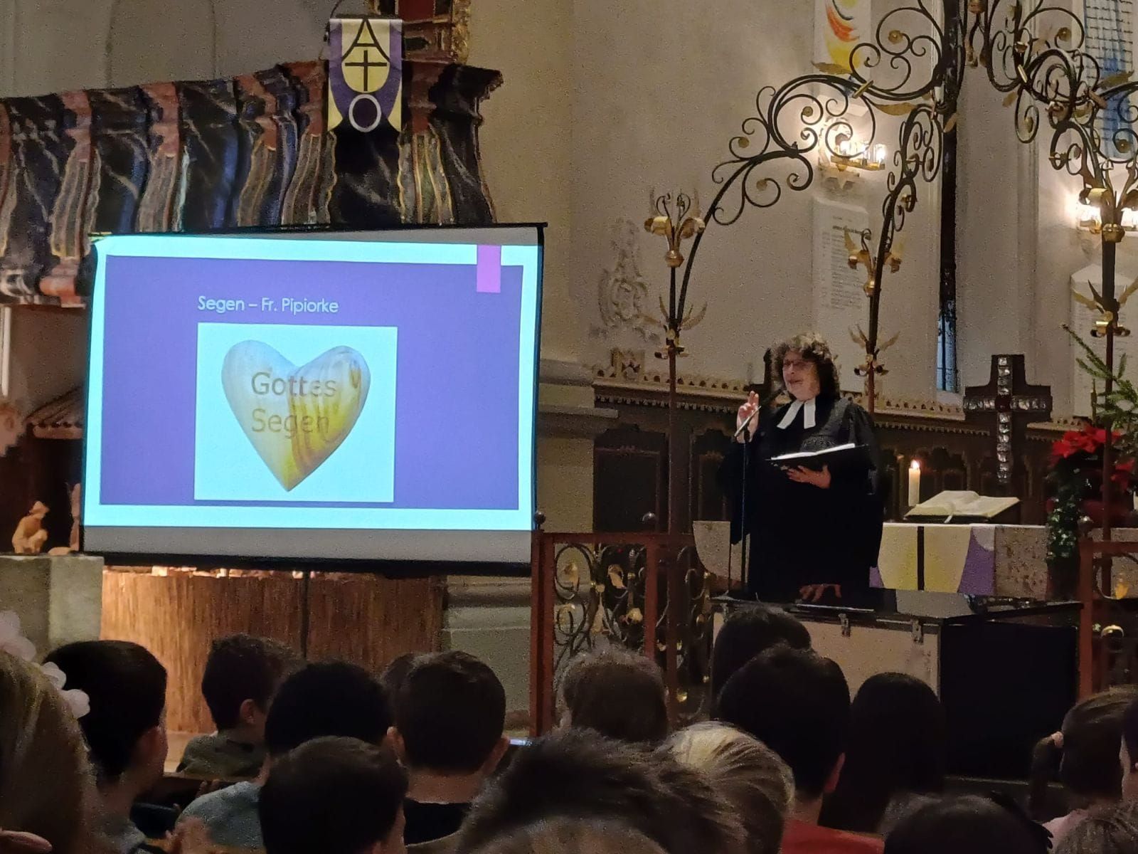 Pfarrerin spricht vor Kindern.