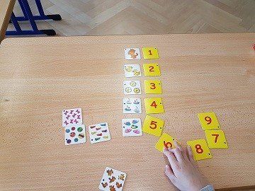 Ein Kind spielt eine Lernspiel mit Karten auf denen Zahlen sind