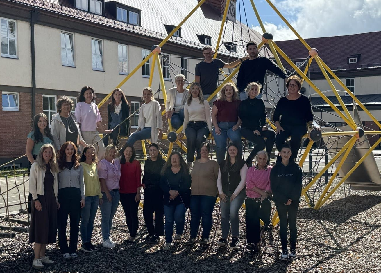 Das Lehrerteam der Friedensschule auf dem Klettergerüst im Schulhof der Friedensschule.