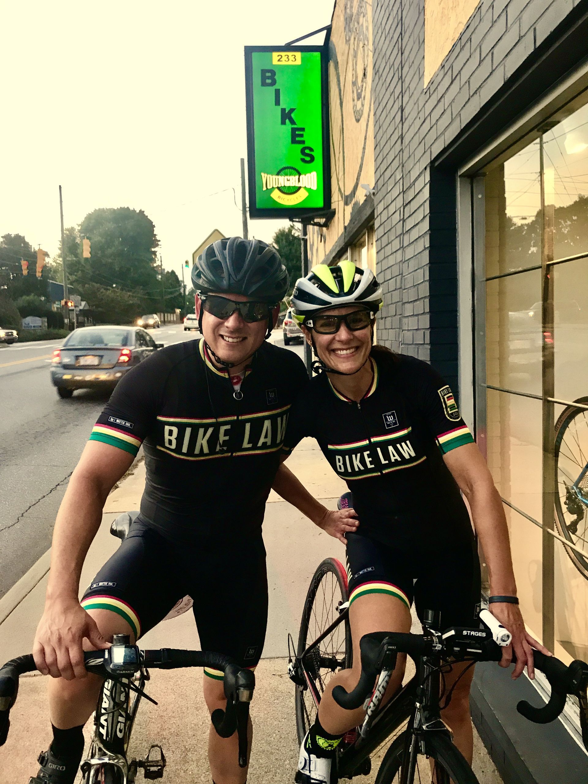 A male and female cyclist in kits that say 