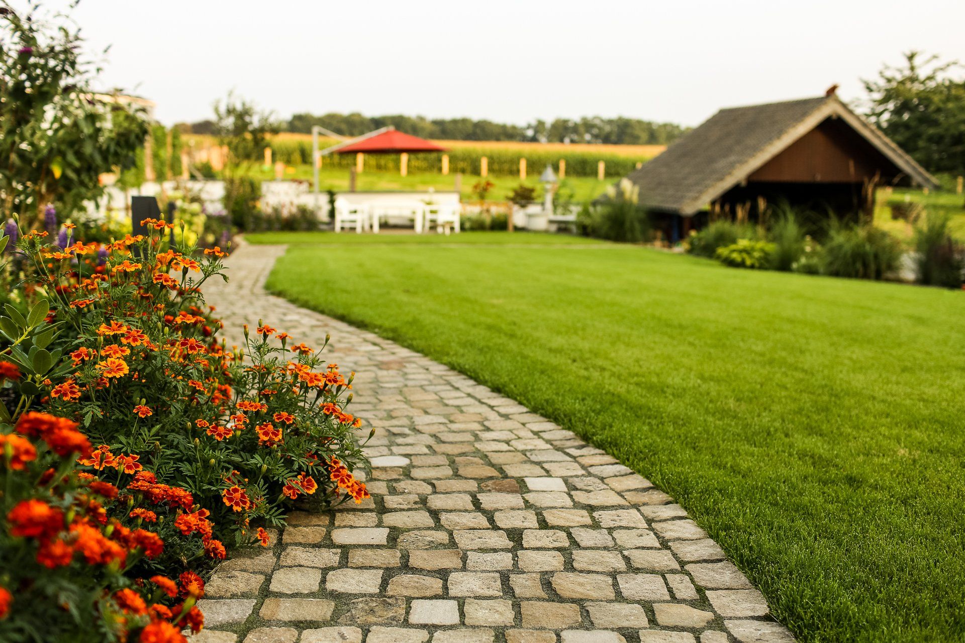 Weg aus Naturstein mit Blumenbeet und Rasenfläche – Gartenbau und Landschaftsgestaltung von Galabau Lange