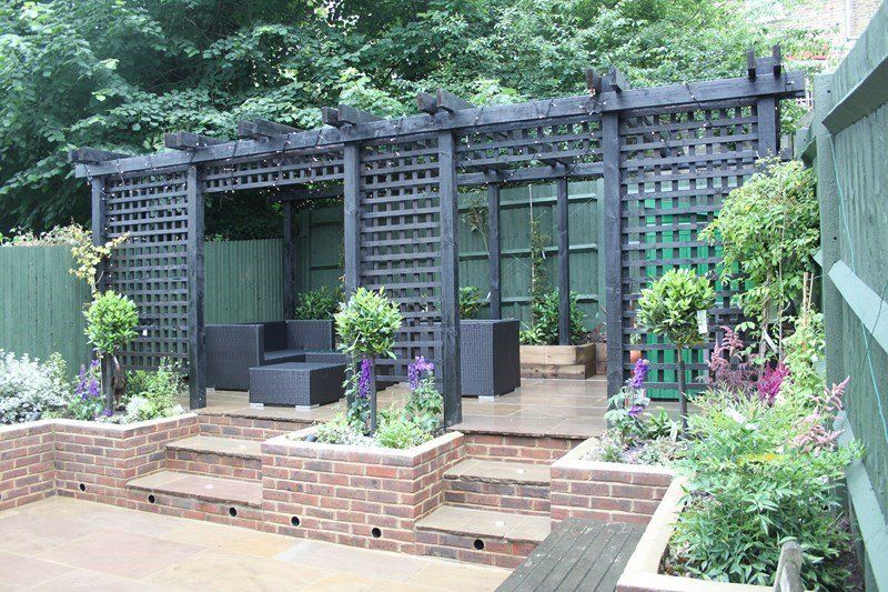 London Garden Builders design Large back garden  great idea Pergola with treelis, raised brick wall with steps and Indian Sandstone paving