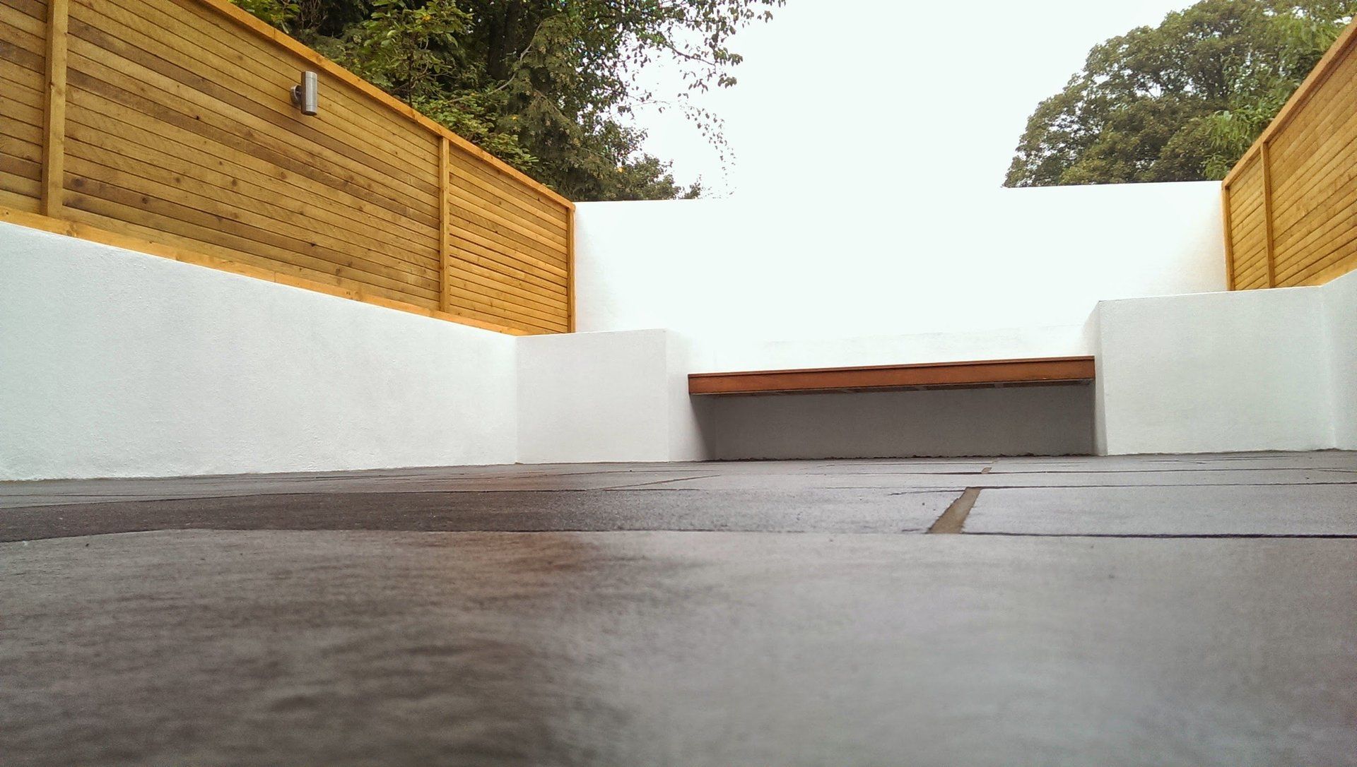 black limestone paving softwood horizontal screen fence hardwood bench rendered walls and beds london garden builders