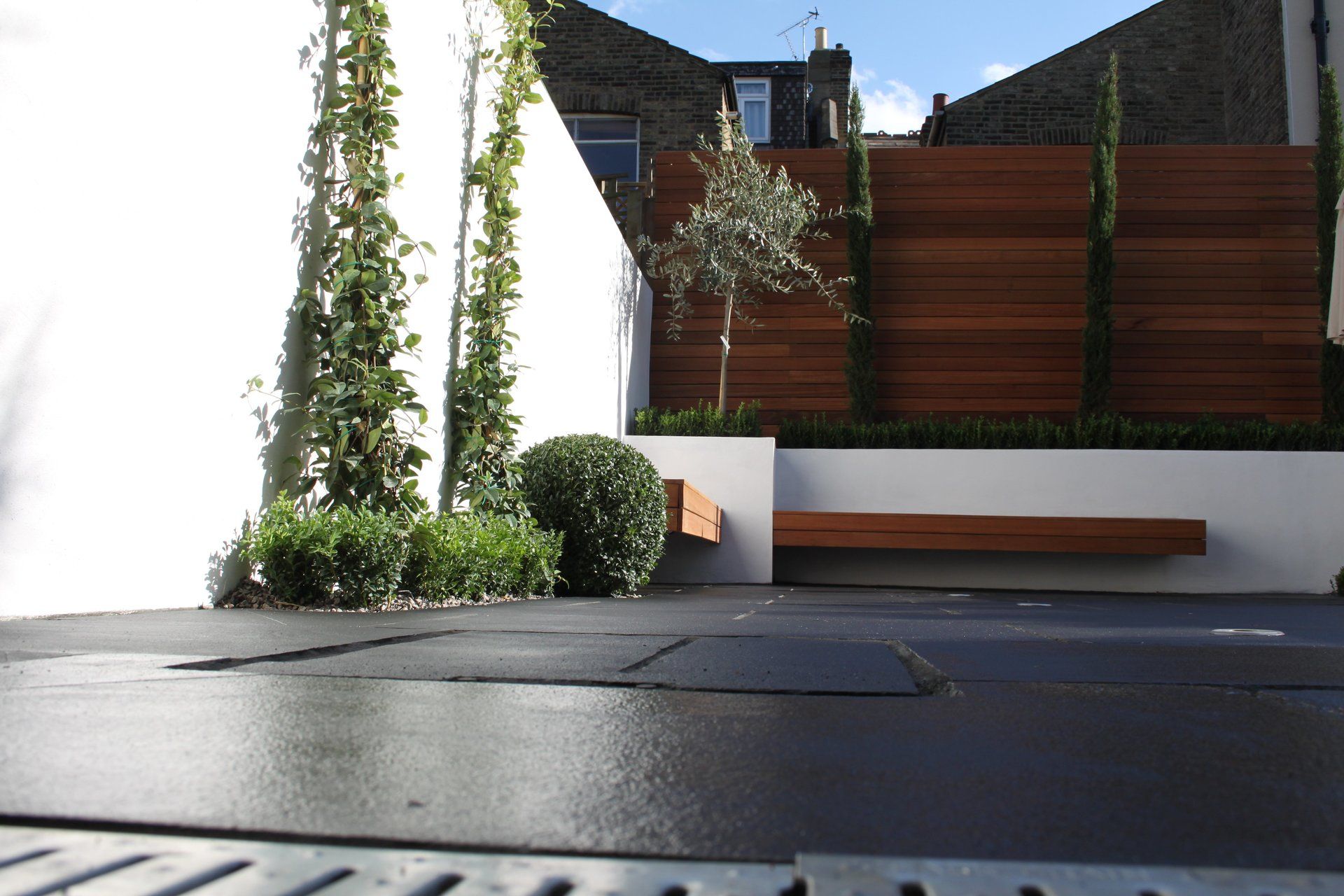 London Garden Builders black limestone,modern garden,floating bench,hardwood fence,retaining wall, raised beds