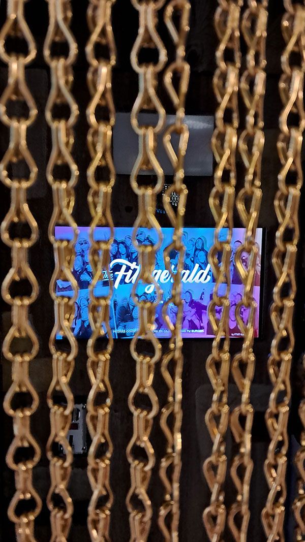 Cabina de fotomatón de estilo vintage con fondo de cadenas en la hamburguesería Fitzgerard de Sevilla.