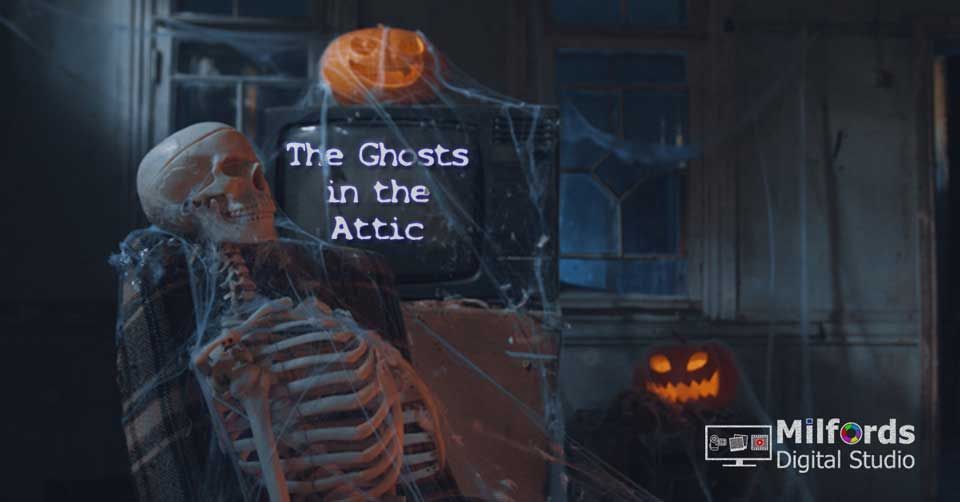 A skeleton covered in cobwebs sits before an old TV with pumpkins in eerily, spooky room.
