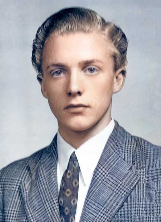 Young man with light hair wearing a patterned suit and tie.