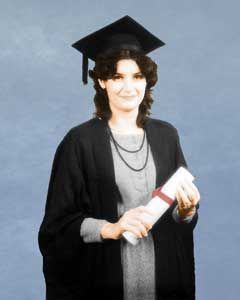 Smiling woman in graduation cap and gown holding diploma against blue background.
