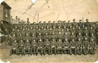 Black and white photo of army personnel in uniform before restoration.