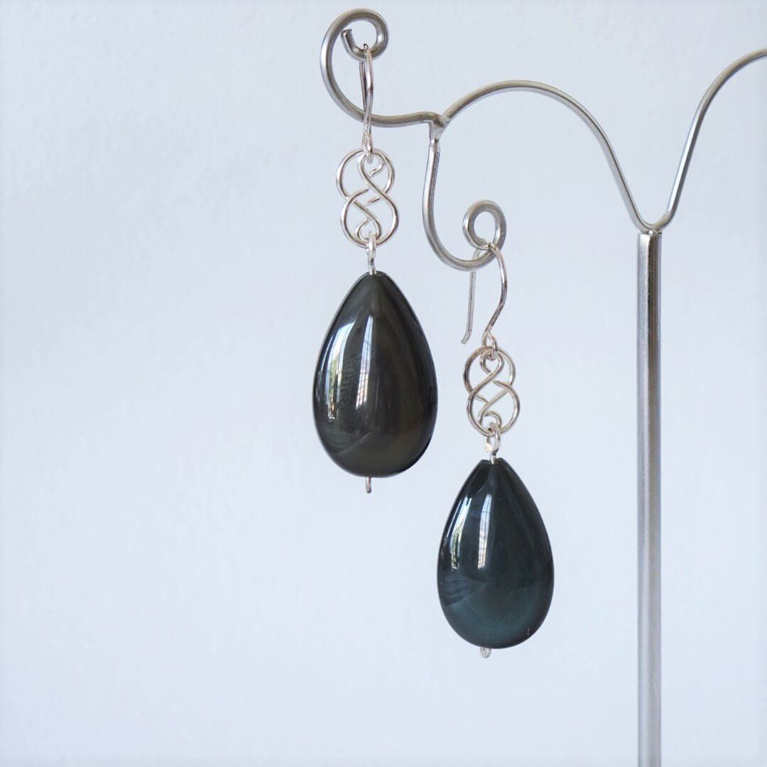 cette photo représente une paire de boucles d'oreilles en argent et pierres fines naturelles obsidienne arc-en-ciel appelée aussi obsidienne œil céleste à découvrir sur https://www.nathalyne.fr