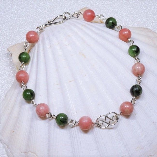 Cette image représente un bracelet en rubis sur zoïsite et thulite sur argent massif par Nathalyne. Un bracelet en pierres pour l'espoir et le courage.