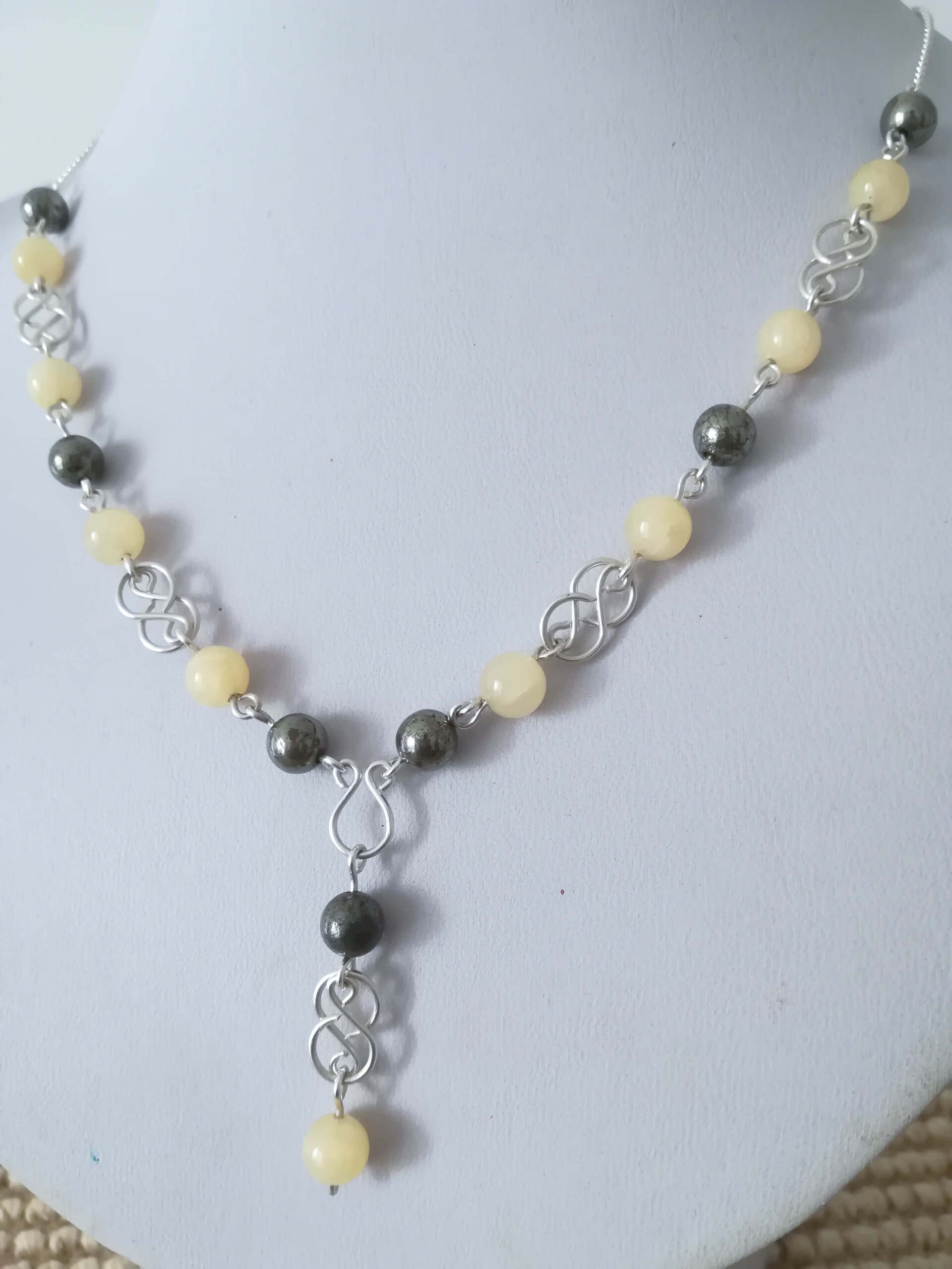 Cette photo représente un collier en argent, aragonite et pyrite, fabriqué par Nathalyne.